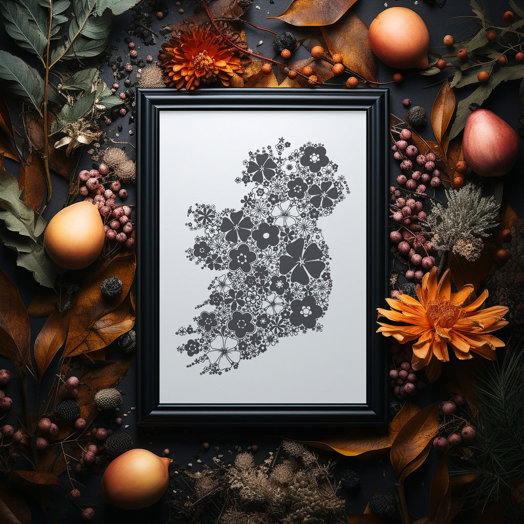 Black floral Ireland screen print in a black frame on dark background surrounded by Autumnal flowers and foliage