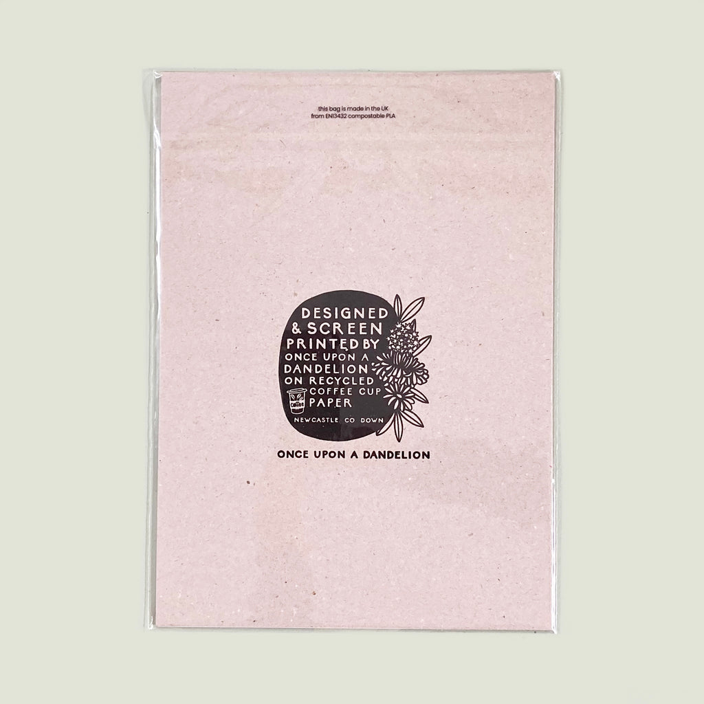 A photo of the backing card and plastic free,  compostable packaging  that protects our screen prints.  The recyclable backing card is screen printed with our once upon a dandelion logo and details about the screen print