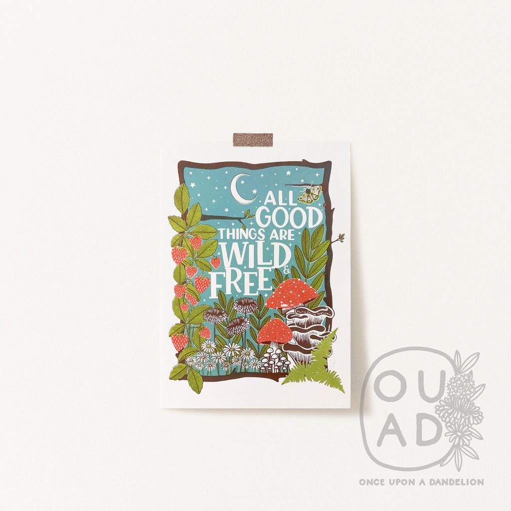 Our 'All good things are wild and free' screen print featuring hand lettering, mushrooms, dandelions, daisies and strawberries in moonlight.  The print is stuck to the wall with tape.