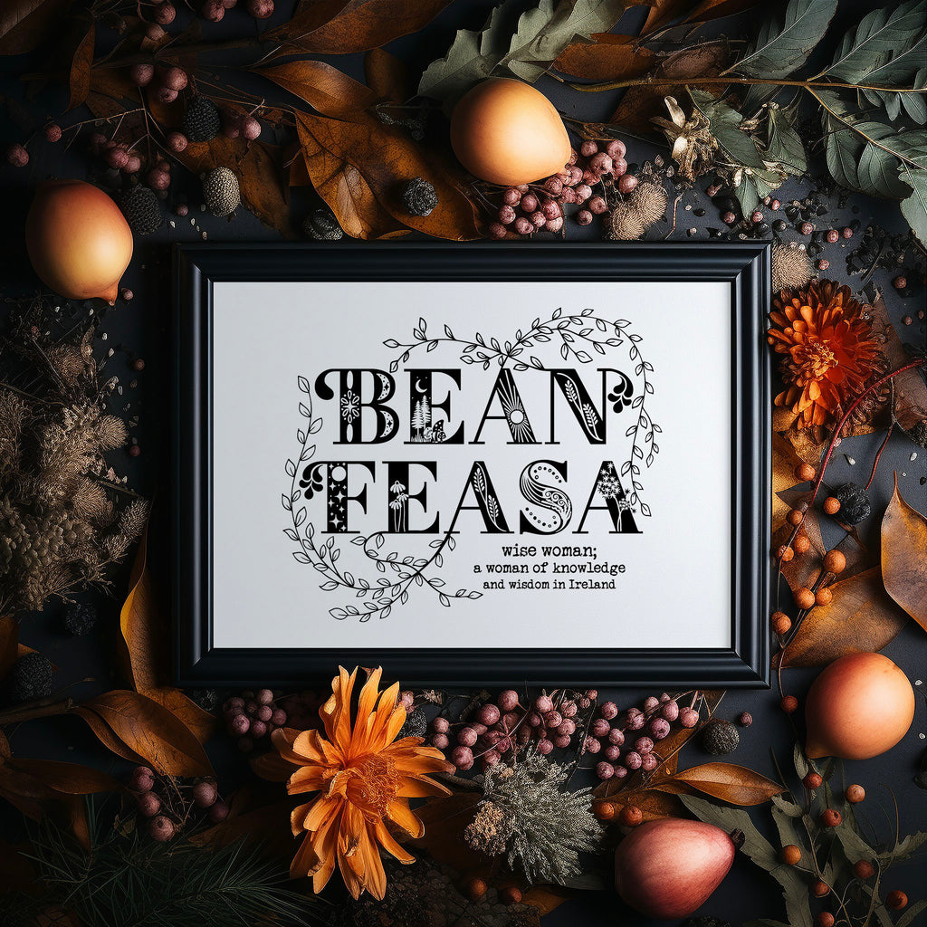 Our Irish language screen print, bean feasa, in a black frame surrounded by Autumn foliage, flowers and fruit.
