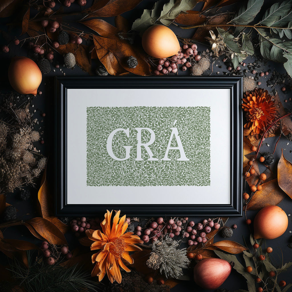 Our green Grá screen print in a black frame surrounded by Autumn foliage, flowers and fruit.
