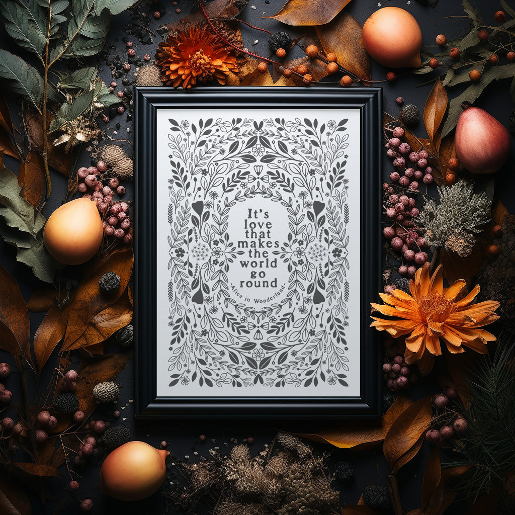 Grey and white screen print in a black frame on a dark background surrounded by Autumnal flowers and foliage