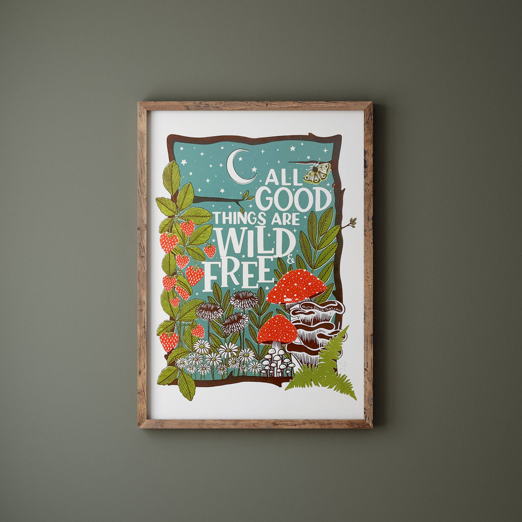 Wild and free screen print in a wood frame hanging on a green wall